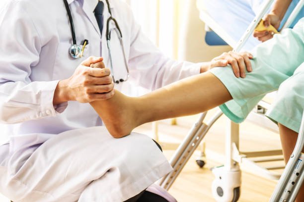 Doctor and patient - Doctor examining of the leg from the knee and ankle and training broken leg patient in hospital - physical therapy concept